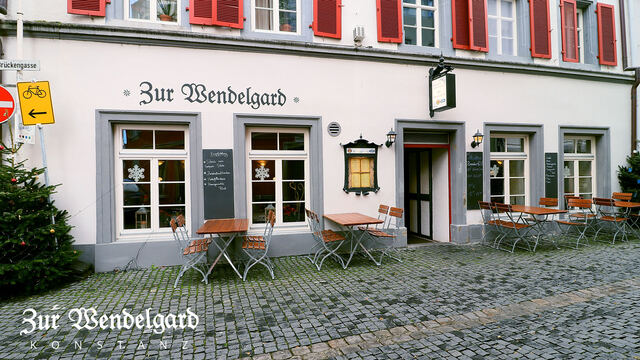 Außenansicht des Restaurants mit Tischen auf der Gasse